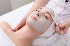 Woman doing facial massage on herself with hands on cheeks, glowing skin